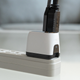 The Human Things Genki Covert Dock Mini plugged into a power bar, with an HDMI and USB-C cable attached.
